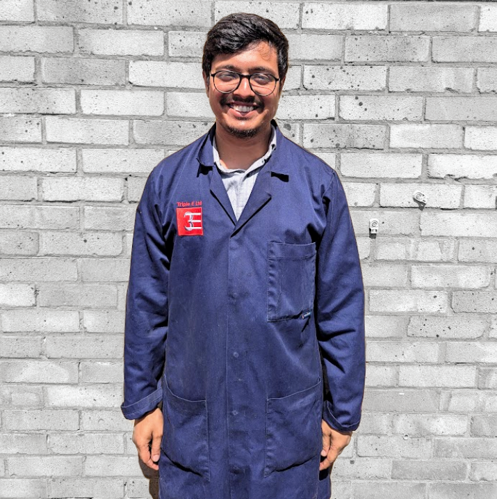 milan stood in front of wall smiling